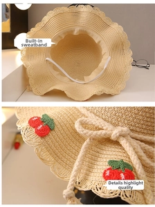 Detail of child straw sun hat with inner sweatband and crochet cherry decoration