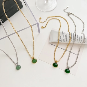 Luxury Aventurine stone jewelry set with gold and silver necklaces on a white desk