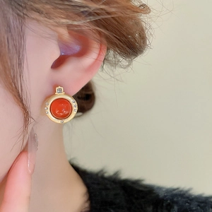 Gros plan d'une boucle d'oreille vintage en onyx rouge avec base dorée et cristaux