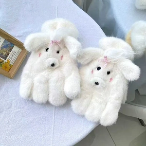 Close-up of white plush dog gloves with pink checkered bows and soft faux fur texture
