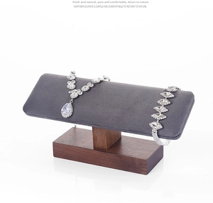 Close-up of sparkling rhinestone necklace and bracelet set on a dark wood display stand