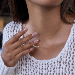 Close-up of 18K gold stainless steel necklace with five elegant pearl smile charms