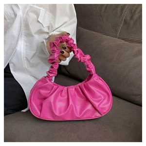 Detail of rose red pleated cloud bag with soft leather texture and stylish handle