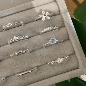 Collection of 8 minimalist 925 sterling silver adjustable rings on a jewelry tray