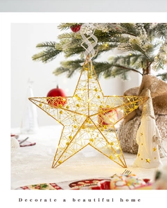 Dettaglio di una stella di Natale dorata con luci LED calde su un albero bianco