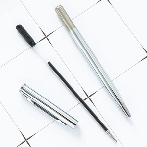 Polished silver metal ballpoint pen with disassembled components and black ink refill