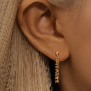 Close-up of elegant gold tassel chain earrings on ear for a minimalist jewelry look
