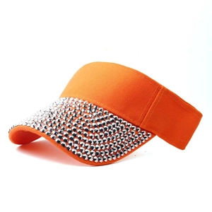 Detailed view of shiny silver rhinestones on a bright orange canvas visor hat brim