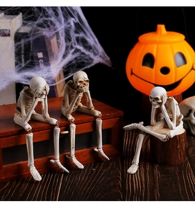 Three resin skeletons set in hear see speak no evil poses with Halloween pumpkin decor