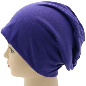 Detail view of purple slouchy knit beanie showing soft cotton texture and stretchable fit