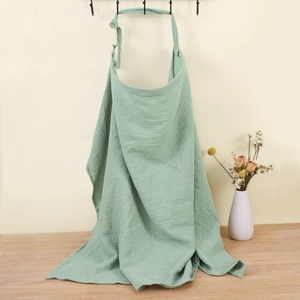Detail of light green cotton muslin nursing cover showing textured breathable fabric