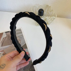 Detail of black braided headband with gold chain trim and non-slip inner teeth design