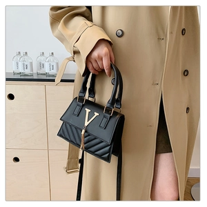 Chic black quilted crossbody bag with gold V-hardware and stylish tassel detail
