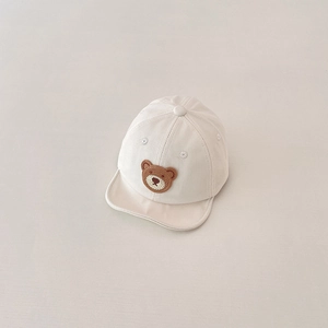 Close-up of cream baby baseball cap featuring a cute brown bear embroidery and breathable holes