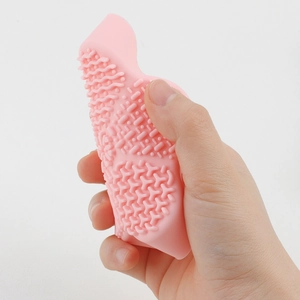Flexible pink silicone makeup brush cleaner mat showing soft texture and scrubbing nodules