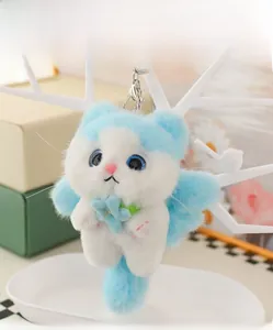 Detail of blue and white plush cat keychain with soft fur holding a light blue flower