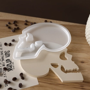 Makro-Detail einer Totenkopf-Silikonform mit passendem Sockel auf Holzoberfläche