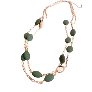 Double-layer rose gold chain necklace with olive green beads on a white background