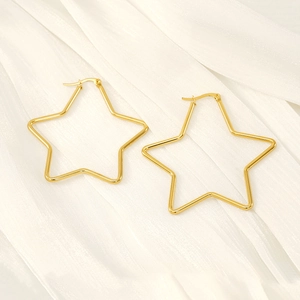 Polished gold plated stainless steel star hoop earrings on white textured fabric