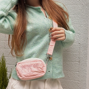 Detail der rosa bestickten Schleifen-Umhängetasche mit verstellbarem breitem Schultergurt