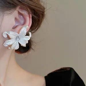 Elegant white lily acrylic earrings with zircon center shown on model for stylish look