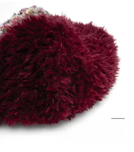 Détail macro du pompon en fausse fourrure bordeaux avec couture supérieure renforcée