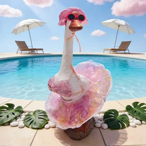Garden goose statue dressed in pink bikini and sunglasses by the outdoor pool
