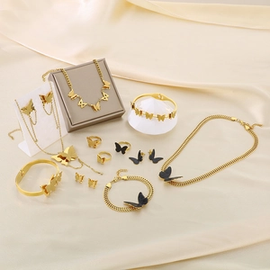 Elegant gold and black butterfly jewelry set on silk background with necklace and earrings