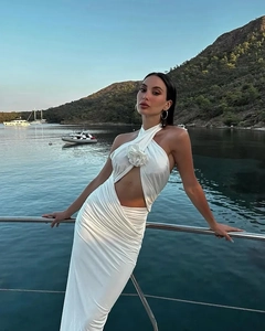 Detail of white cutout dress with floral applique on the bodice by the coast