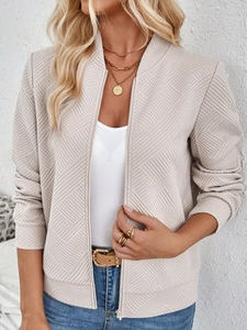Detailed view of beige textured bomber jacket with geometric jacquard fabric and metal zipper