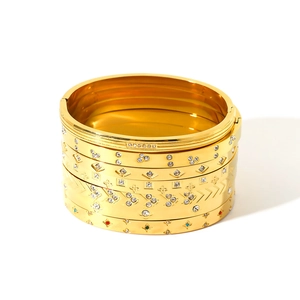 Ensemble de cinq bracelets en acier doré ornés de strass brillants et motifs d'étoiles
