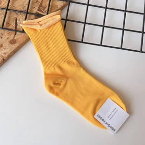 Bright yellow mid-calf cotton socks with vertical ribbed texture and brand tag