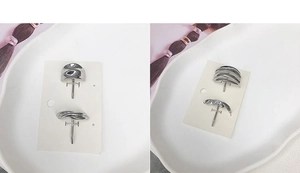 Macro shot of silver minimalist irregular geometric metal stud earrings on a white card