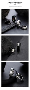 Macro detail of industrial style silver and black ear clips with THG lettering on stone