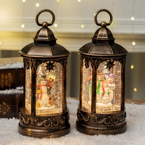 Set of two vintage bronze Christmas lanterns with glowing snowman scene and swirling snow