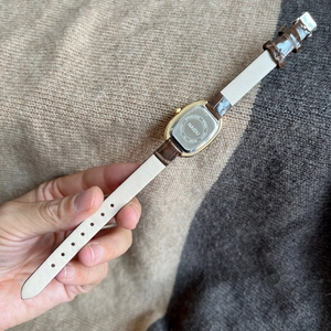 Detailed back view of the NAIDU oval watch showing the stainless steel case and leather strap