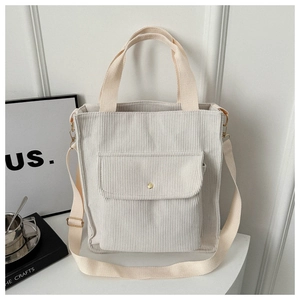 Detail view of cream white corduroy tote bag with front pocket and adjustable strap