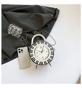 Detail view of the creative piano and clock dial pattern on the white round handbag