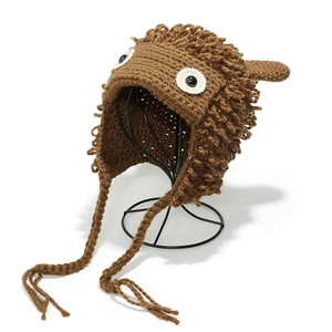 Detail of handmade crochet earflap hat with big white eyes on a metal stand