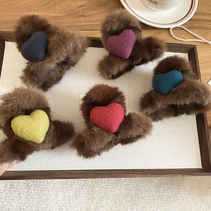 Vue détaillée de cinq pinces à cheveux en peluche marron avec des cœurs en feutre colorés