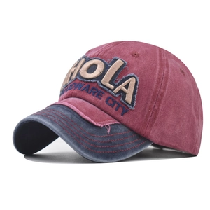Close-up of vintage washed baseball cap with Hola embroidery and distressed patchwork details