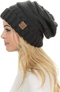 Detail of dark grey cable knit beanie with premium texture and leather brand label