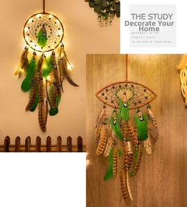 Detail of bohemian dreamcatcher with warm LED lights and green striped feathers