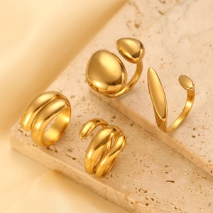 Detailed view of 18K gold plated asymmetric water-drop rings on stone and satin surface