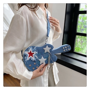 Dettaglio della borsa a tracolla in denim a forma di chitarra con stelle e catene