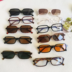 Flat lay of vintage rectangular sunglasses in various colors on a textured surface
