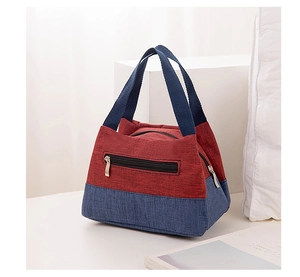 Detail of red and blue fabric lunch bag showing woven texture and functional zipper pocket