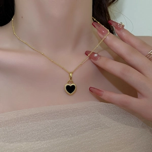 Elegant gold titanium necklace with double-sided heart pendant on female model