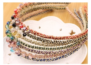 Close-up of colorful braided headband with crystal beads on a wooden background