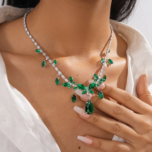 Close-up of vintage butterfly droplet necklace with green crystals on a model